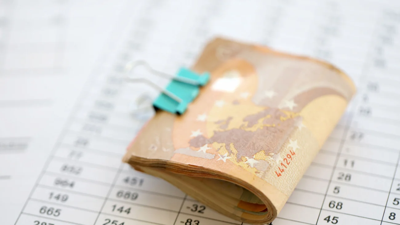 Heap of euro money bills in stationery clip on papers with calculations and receipts. Business and accounting concept